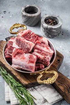 Fresh Raw diced beef marbled meat in steel skillet with herbs ready for cooking Stock Photos