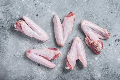 Fresh raw duck wings on kitchen table. Gray background. Top view Stock Photos