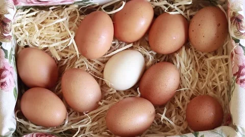 Fresh raw eggs in a wicker square filled basket, top view Stock Footage 233602028
