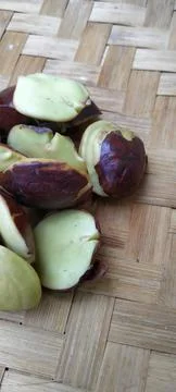 Fresh Raw Jengkol Seeds on a Rustic Bamboo Mat Top View Stock Photos