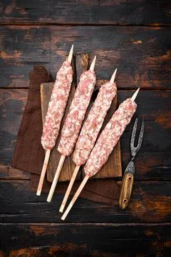Fresh Raw kofta or lula kebabs skewers, on old dark wooden table background,  Stock Photos