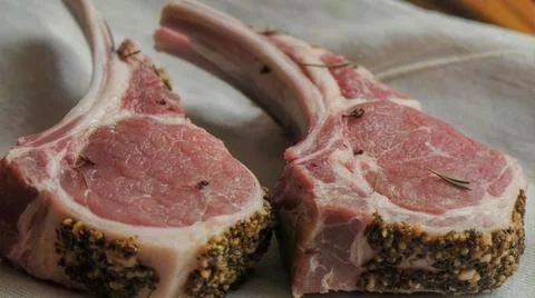 Fresh raw lamb chops with herbs and spices on a wooden board Stock Photos