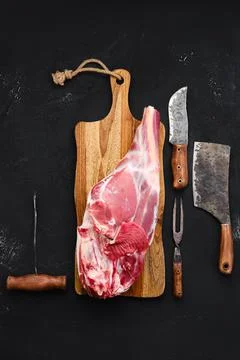 Fresh raw lamb leg bone in on wooden cutting board Stock Photos