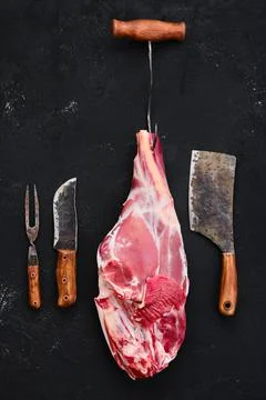 Fresh raw lamb leg bone in on wooden cutting board Stock Photos
