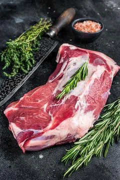 Fresh Raw lamb mutton shoulder meat with butcher knife. Black background. Top Stock Photos