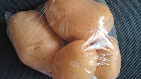 Fresh raw organic potatoes inside clear plastic packaging video motion clip Stock Footage 339374496