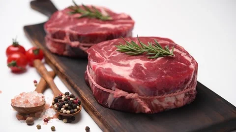 Fresh raw pieces of beef meat on a cutting board isolated on white background Видео 153008689