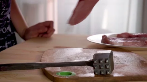 Fresh raw pork meat on the table, woman beats meat. Close up slow-mo Stock Footage 95131647