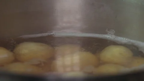 Fresh Raw Potatoes Boiling in a Large Metal Pot on a Stovetop Kitchen Setting Stock Footage 339630499
