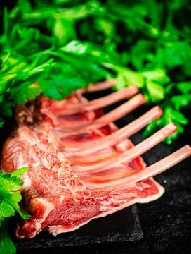 Fresh raw rack of lamb on a stone board with parsley. Stock Photos