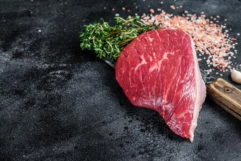 Fresh Raw rump beef cut or top sirloin cap steak on butcher cleaver. Black Stock Photos