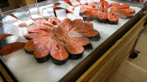 Fresh raw salmon fillet on ice on the counter in a fish store. red fish fillets Stock Photos