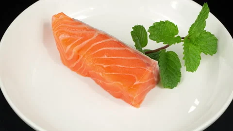 Fresh Raw Salmon Fillet Rotating on White Plate Stock Footage 342618222