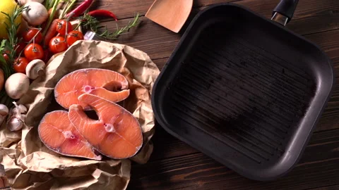 Fresh raw salmon fish steak with herbs and vegetables on wooden background Stockbeeldmateriaal 145185831