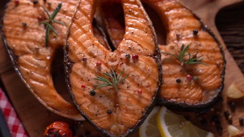 Fresh raw salmon fish steak with herbs and vegetables on wooden background Видео 147240185