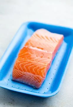 Fresh raw salmon in plastic container, close up view. Stock Photos
