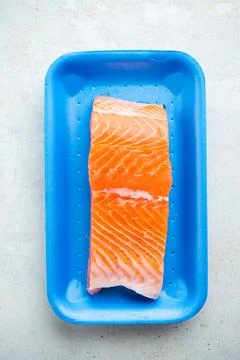 Fresh raw salmon in plastic container, close up view. Stock Photos