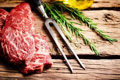 Fresh raw steak with fork. Stock Photos