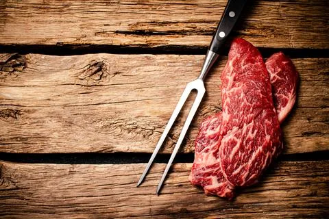 Fresh raw steak with fork. Stock Photos