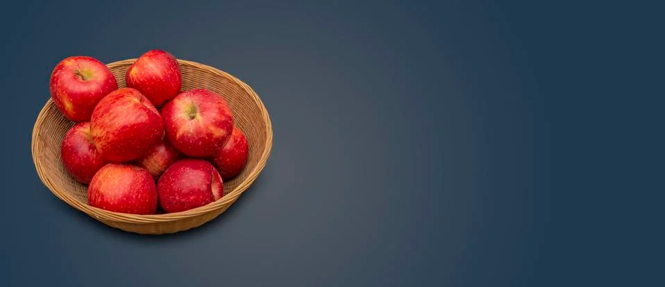 Fresh red apples in basket on navy blue background banner with copy space Foto stock
