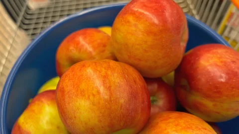 Fresh red apples stacked in blue bowl inside grocery shopping cart Stock Footage 339248406