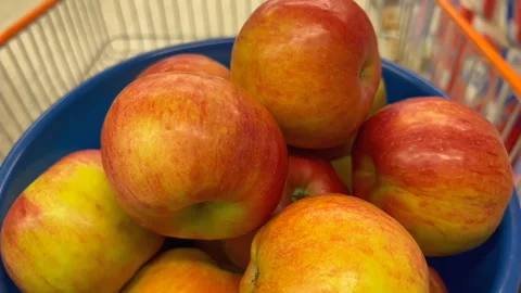 Fresh red apples stacked in blue bowl inside grocery shopping cart Vídeos de archivo 344752709