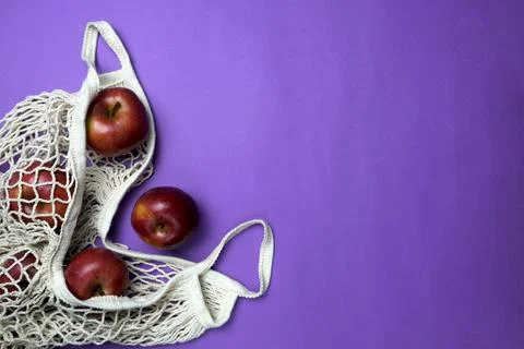 Fresh red apples in a string bag. Natural materials and natural products. Stock Photos