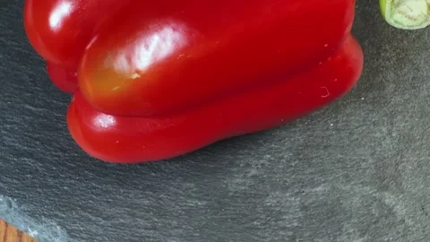 Fresh red bell pepper on a black slate flat plate 動画素材 337653586