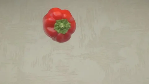 A Fresh Red Bell Pepper Falling Gracefully on a Light Surface with Bright Colors Видео 284317828