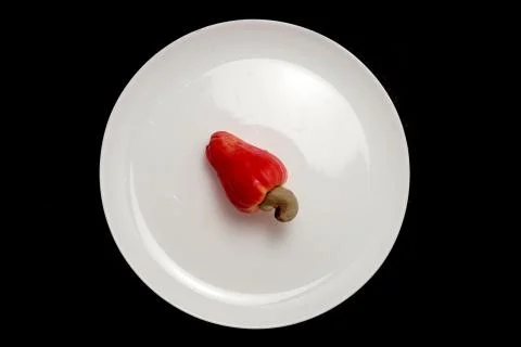 Fresh red cashew fruit on white plate Stock Photos
