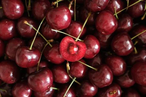 Fresh red cherries with one cut open Stock Photos