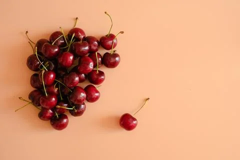 Fresh red cherries on peach background Stock Photos