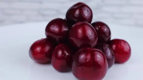 Fresh red cherry rotates on a round white table. Close-up, slow motion Vídeo Stock 134882488