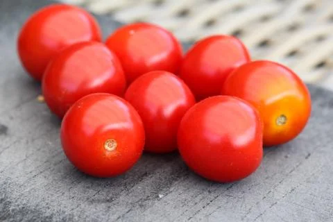Fresh red cherry tomato on black cutting board background Stock Photos