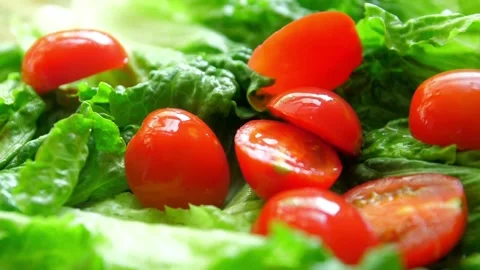 Fresh red cherry tomatoes falling on green lettuce leaves Stock-Footage 332279009