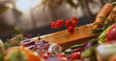 Fresh red cherry tomatoes falling and bouncing on wooden cutting board in k.. Видео 337524434