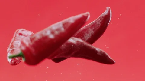 Fresh red chilli pepper and ejection in red background. 動画素材 128420558