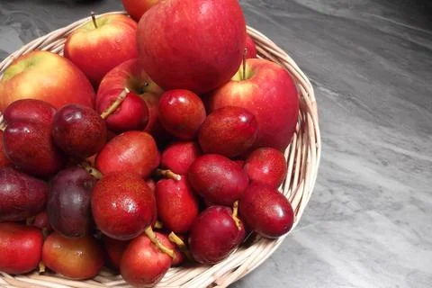 Fresh red dates and apples ready to eat in a basket Stock Photos