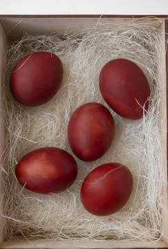 Fresh red eggs and some straw in a wooden crate on a white background. Chicke Stock Photos