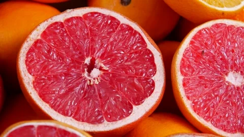 Fresh red grapefruit halves on display with orange fruits close up shot in .. Stock Footage 332909293