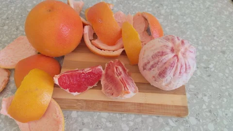 Fresh red grapefruits, grapefruit slices and peel on a wooden cutting board Stock Footage 331010071