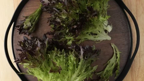 Fresh red leaf lettuce rotating on a wooden tray Stock Footage 344604734