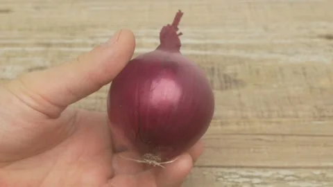 A Fresh Red Onion is held in Hand, ready to be used in various exciting recipes Vídeo Stock 287117408