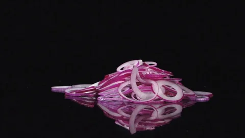 Fresh red onion rotating and rolling on a black mirror table. Stock Footage 113204645