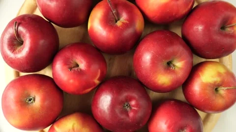 Fresh red ripe apples rotating on wooden plate 库存影片 335435338