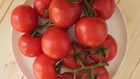Fresh red ripe tomatoes rotating on a plate Видео 338312361