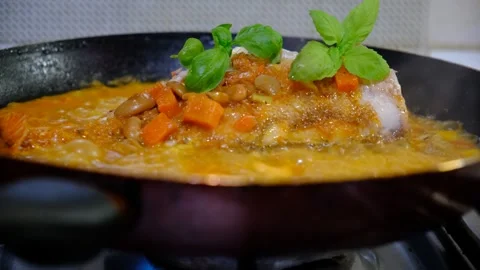 Fresh Red Snapper hot in the frying pan with carrot, garlic, basil,  savoury Stock Footage 334824966