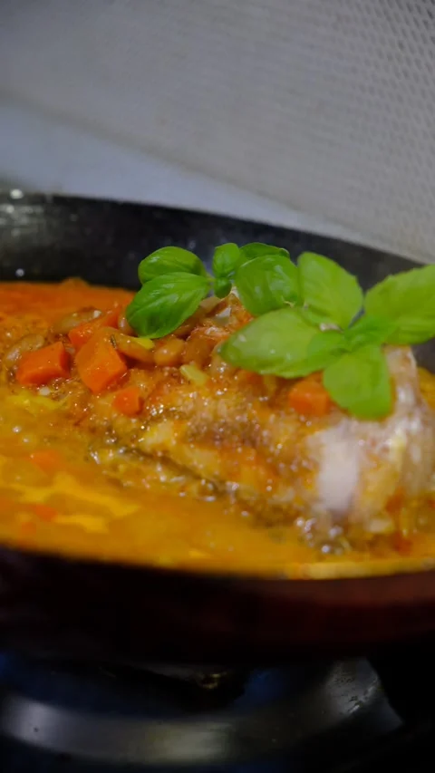 Fresh Red Snapper hot in the frying pan with carrot, garlic, basil,  savoury Stock Footage 334828764