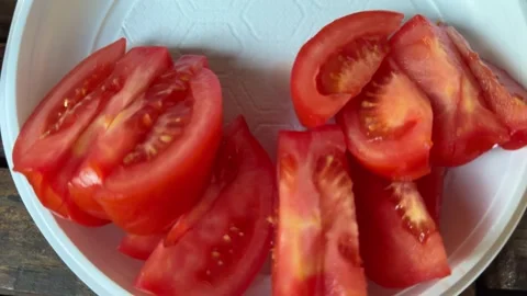 Fresh red tomato slices prepared on wooden cutting board and placed onto grill Stock Footage 345726253