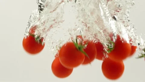 Fresh red tomato splash falling down into water Stock Footage 256161713